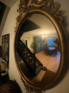 espejo que refleja una habitación con escalera y comedor en Love-Room Chic&Glam', en Saint-Vincent-de-Paul