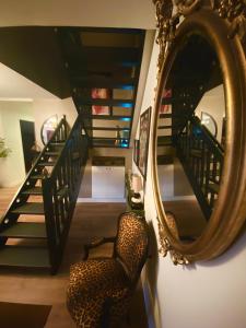 a room with a mirror and a chair and stairs at Love-Room Chic&Glam' in Saint-Vincent-de-Paul