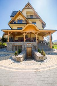 a large house with a large wooden gazebo at Pod Modrzewiami in Zakopane