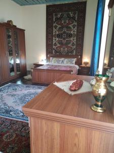 ein Zimmer mit 2 Betten und einem Tisch mit einem Tisch und einem Tisch mit einer Tabelleteryasteryasteryastery in der Unterkunft Ali Ancient House 555 in Şəki