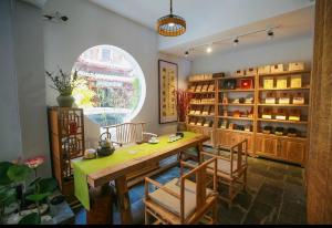 una sala da pranzo con tavolo, sedie e finestra di Tea House a Zhangjiajie