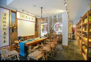 un restaurante con una mesa larga y sillas en Tea House, en Zhangjiajie