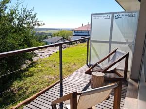 una silla en el balcón con vistas a un campo en Las Piedras VIP Lodging en Sierra de los Padres