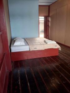Łóżko w pokoju z drewnianą podłogą w obiekcie Don Det Sokxay and Mamapieng Budget Guesthouse w mieście Don Det