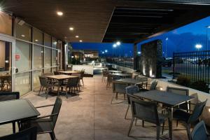 a restaurant patio with tables and chairs at night at Four Points by Sheraton Kansas City Olathe in Olathe