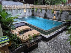 una piscina in un giardino con piante di Sampara Ubud with Mindrum Group ad Ubud