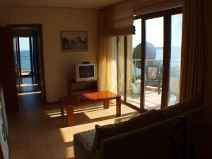 a living room with a couch and a table and window at Nessebar View Apartament in Nesebar