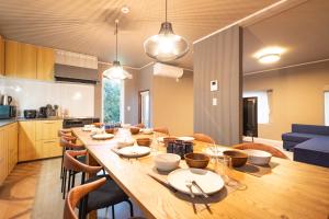 uma sala de jantar e cozinha com uma grande mesa de madeira em VILLA LOUISA em Furano