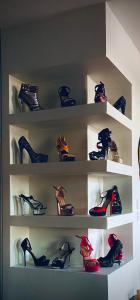 un estante lleno de zapatos y tacones en Love-Room Chic&Glam', en Saint-Vincent-de-Paul