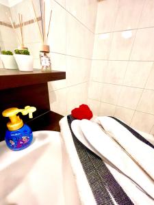 La salle de bains est pourvue de 2 serviettes blanches et d'un lavabo. dans l'établissement 5 Min from Disneyland cozy retreat, à Montévrain