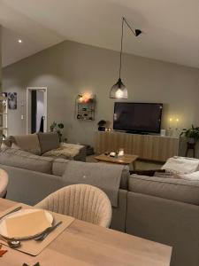 a living room with two couches and a flat screen tv at New luxurious Villa in Helsingborg close to the City in Helsingborg