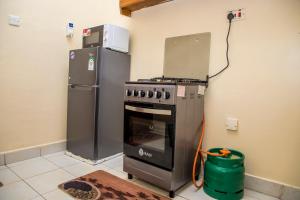 Il comprend une cuisine équipée d'une cuisinière et d'un réfrigérateur. dans l'établissement Elnara Suites, à Machakos