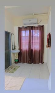 a bathroom with a red shower curtain and a sink at Tunas Cottage 2 in Kuah