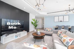 a living room with a couch and a tv at Heaven Crest Holiday Homes Dubai Marina - 4 Bedroom Suite with Marina View near JBR Beach, Free Parking, Wi-Fi, Gym and Pool in Dubai