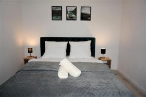 1 dormitorio con 1 cama con almohadas blancas y 2 lámparas en Apartament Barskich, en Rzeszów