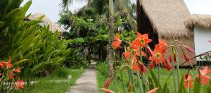 a path in front of a house with flowers at Mengalung Bungalow in Kuta Lombok