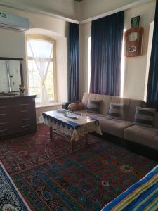 a living room with a couch and a coffee table at Ali Ancient House 555 in Sheki