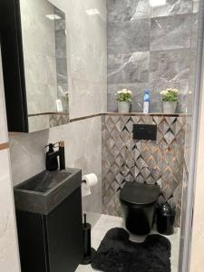 a bathroom with a black toilet and a sink at LuxHome by Lake Neusiedl with Jakuzzi in Fertőszentmiklós +16 photos