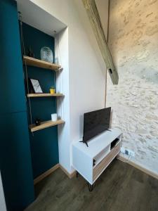 a white cabinet with a tv on top of it in a room at HYPERCENTRE - Entre charme & authenticité - Local vélo in Blois