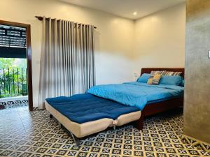 a bedroom with two beds with blue sheets at Eco Inn in Phumĭ Réach Born (2)