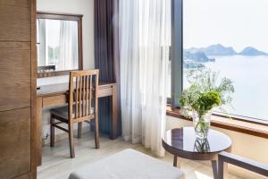 a room with a desk and a table and a window at Cat Ba Paradise Hotel - Sky Bar & Massage in Cat Ba