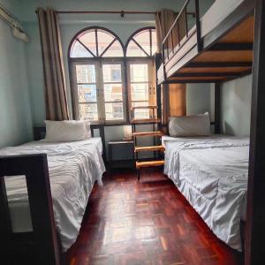 duas camas num quarto com duas janelas em Stay Hostel em Bangkok