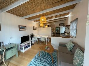 un soggiorno con un divano e un tavolo di Dreamtime Studio a Kommetjie