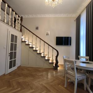 une salle à manger avec un escalier, une table et des chaises dans l'établissement LUBERT APARTMÁNY s.r.o, à Prague
