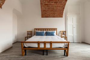 a bedroom with a bed with two chairs at Domus Antiche Mura in Asti