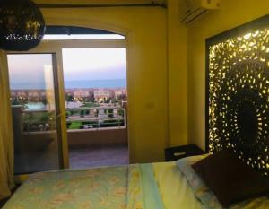 a bedroom with a bed and a large window at Telal sokhna villa families only in Ain Sokhna