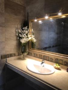 a bathroom sink with a mirror and a vase of flowers at Telal sokhna villa families only in Ain Sokhna +15 photos
