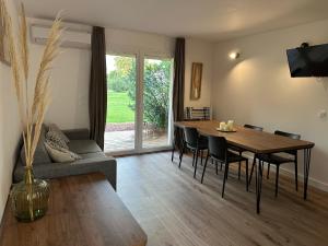 Una sala de estar con una mesa y sillas de madera. en T4 neuf Porto Vecchio Calarossa, en Lecci