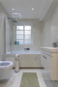 ein weißes Bad mit einer Badewanne und einem WC in der Unterkunft Luxury Apartment in Willesden in London