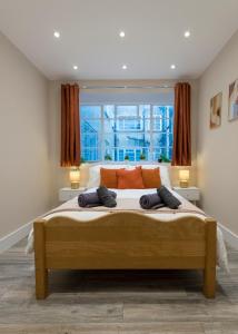 ein Schlafzimmer mit einem großen Bett mit zwei Kissen in der Unterkunft Luxury Apartment in Willesden in London
