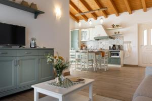 una cucina e un soggiorno con armadi verdi e tavolo di Mos Country House a Tremosine Sul Garda