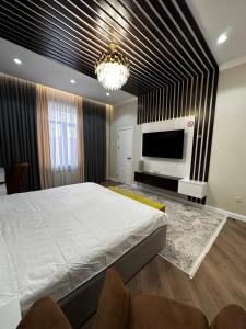 a bedroom with a large bed and a television at Villa Karakol in Karakol