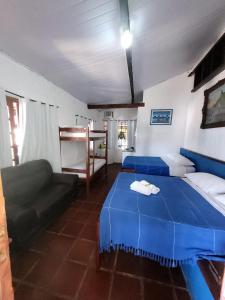 a bedroom with two beds and a couch in it at Pousada Mar Dos Anjos in Arraial do Cabo