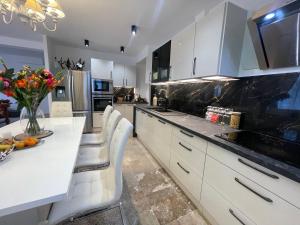 una cucina con armadi bianchi e un tavolo con fiori di Villa Segny a Ségny