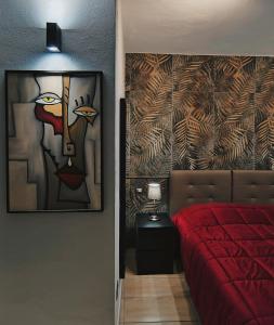 ein Schlafzimmer mit einem roten Bett und einem Gemälde an der Wand in der Unterkunft PALE-H in Bari