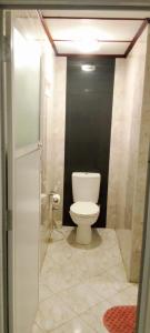a bathroom with a toilet and a black wall at Villa Mare in Wadduwa