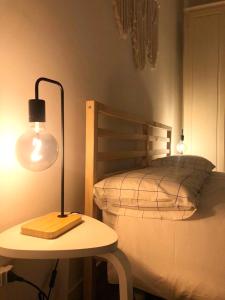 a lamp on a table next to a bed at Maison Bohémienne in Livorno