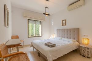 a bedroom with a bed and a desk and a window at TOP VILLA Casa Anna Private Pool Garden Seaview in Benalmádena