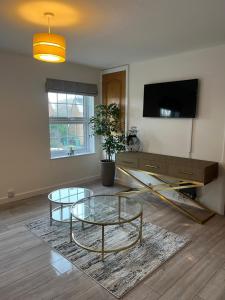 een woonkamer met een glazen tafel en een televisie bij Cosy Apartment in Wetheral,Cumbria in Wetheral
