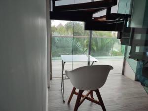 una mesa y una silla en una habitación con ventana en Casa de tus Sueños en Holbox Island
