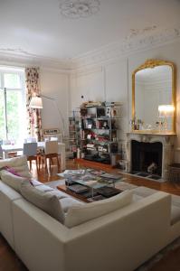 een woonkamer met een witte bank en een spiegel bij Parc Monceau in Parijs