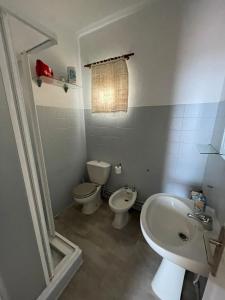 ein Bad mit einem WC, einem Bidet und einem Waschbecken in der Unterkunft Agradable casa con jardín y chimenea interior in Baena