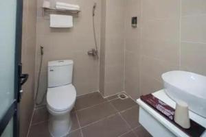 une salle de bain avec des toilettes blanches et un lavabo dans l'établissement Tigon Hotel - 148 Nguyễn Chánh HN by - BAY LUXURY, à Hanoï