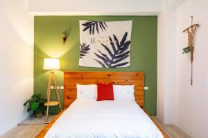 a bedroom with a bed with a green accent wall at 水蛙春 in Hengchun South Gate