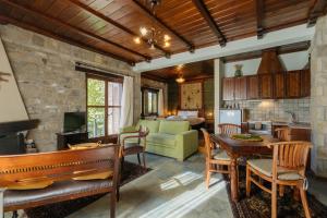 a living room with a piano and a kitchen at Τα Πέτρινα της Ελάτης - Petrina Elatis in Elati