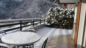 モルヴェーノにあるPra de Dort Casa Vacanzeの雪に覆われた山のバルコニー(テーブル、椅子付)